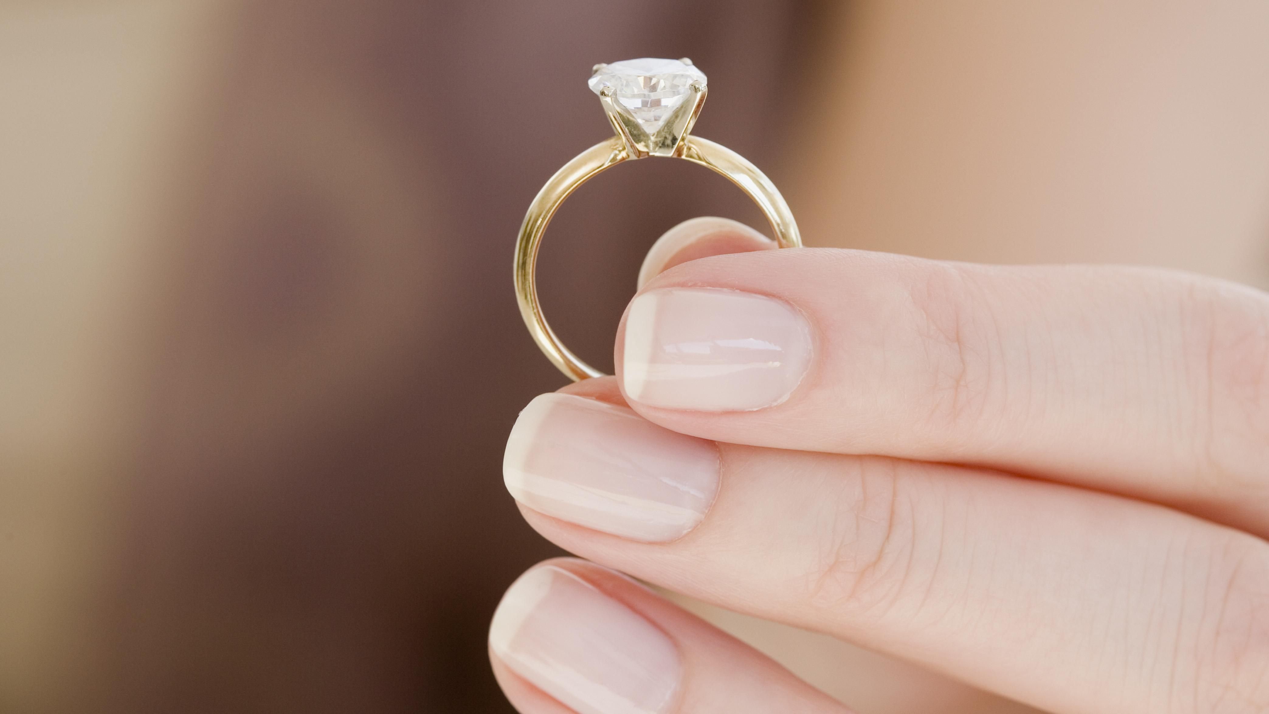 Почему стоит кольцо. Кольцо с бриллиантом на руке. Кольцо в кольце. Кольцо с бриллиантом на руке девушки. Золотое кольцо на пальце.